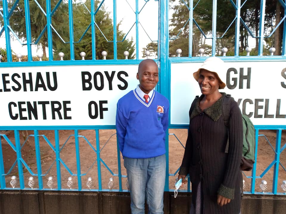 Joseph and his mother posing for a photo, outside the school gate after admission.