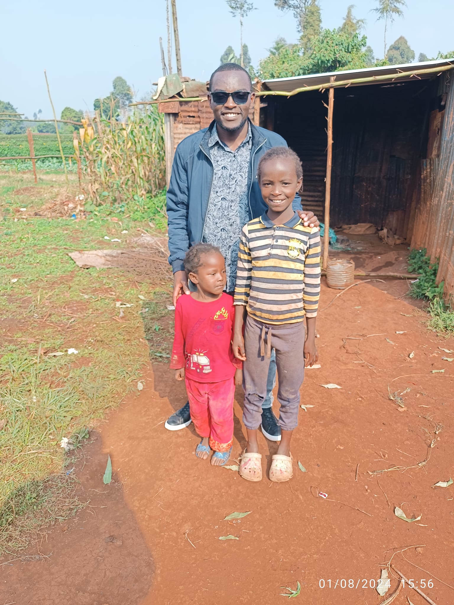 Our founder with the two daughters of the mahogany family, just outside their dilapidated house.